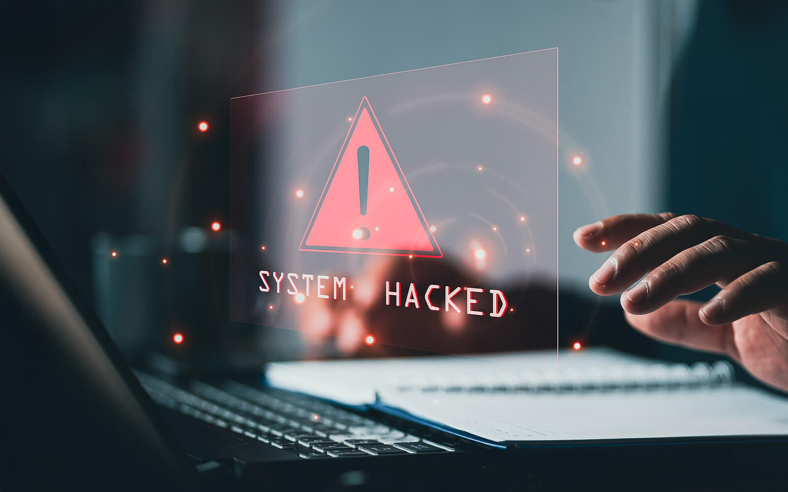 Mensch vor PC, wo drauf steht "System hacked"